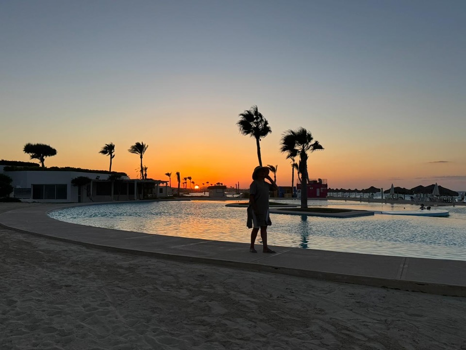May be an image of 1 person, horizon, beach, pool and twilight
