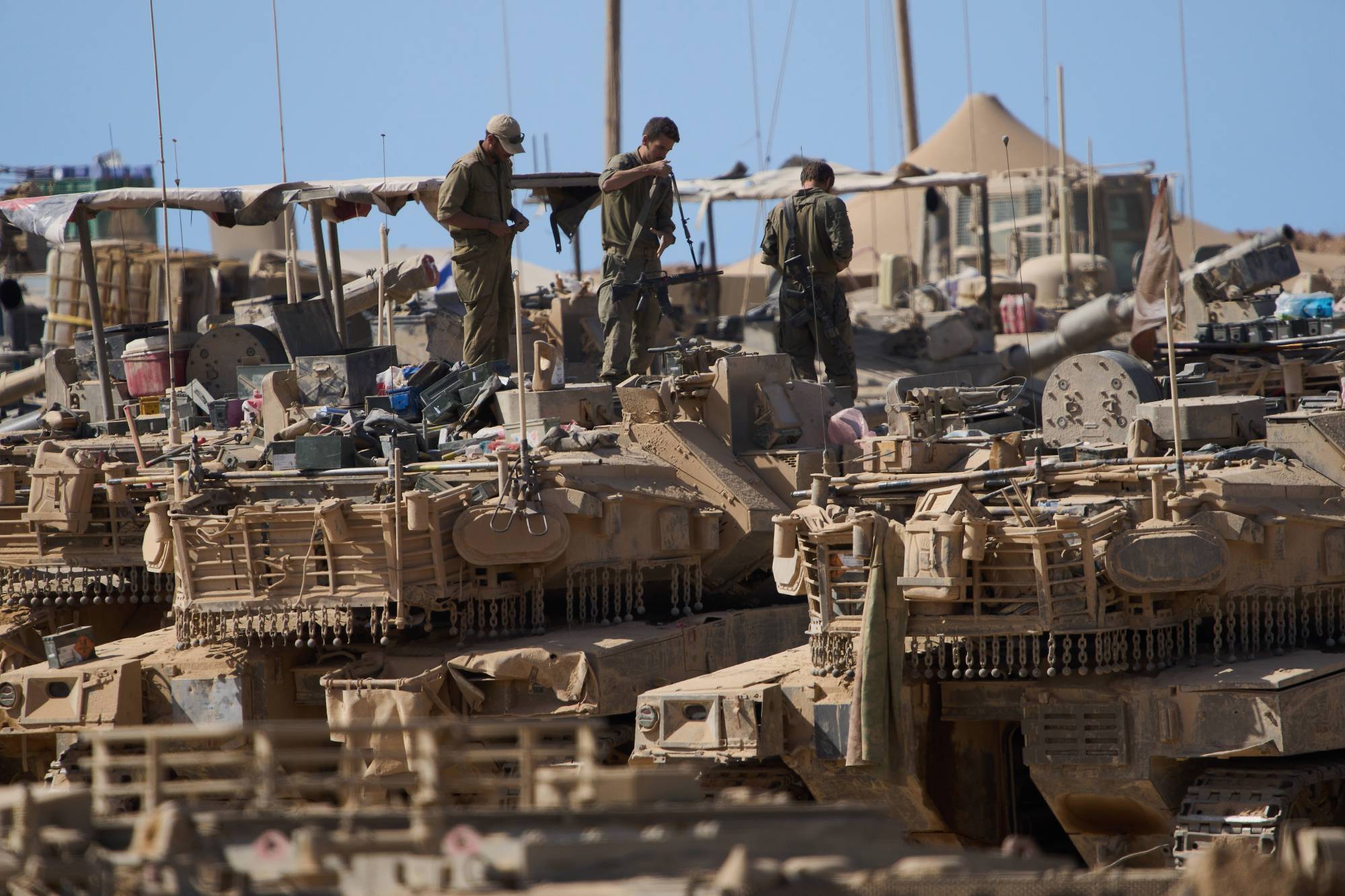 جنود إسرائيليون فوق دباباتهم في موقع على الحدود مع قطاع غزة السبت (أ.ب)