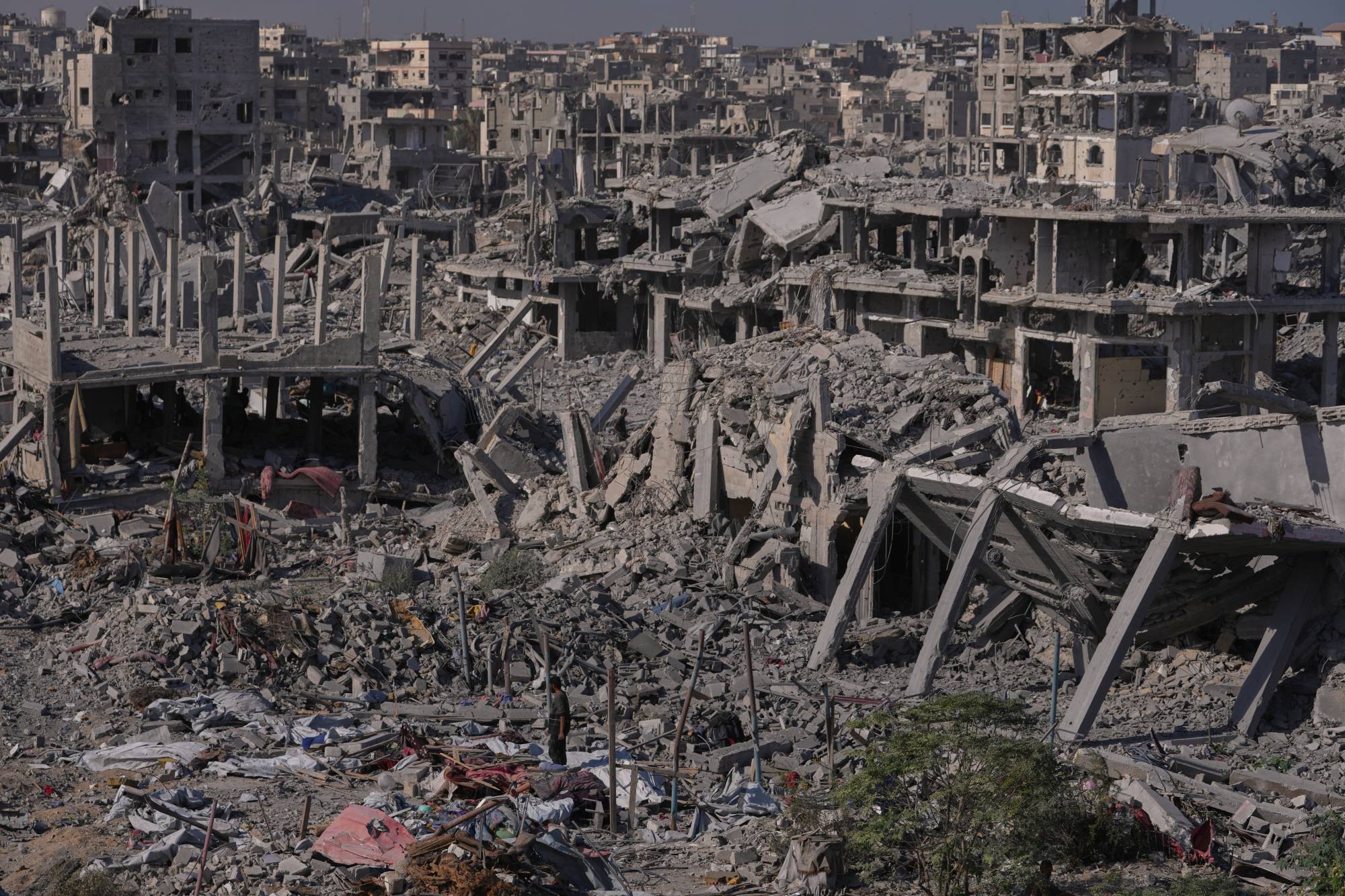 نازحون فلسطينيون يتفقدون منطقة وسط مبانٍ مُدمَّرة في خان يونس بحنوب قطاع غزة السبت (أ.ب)