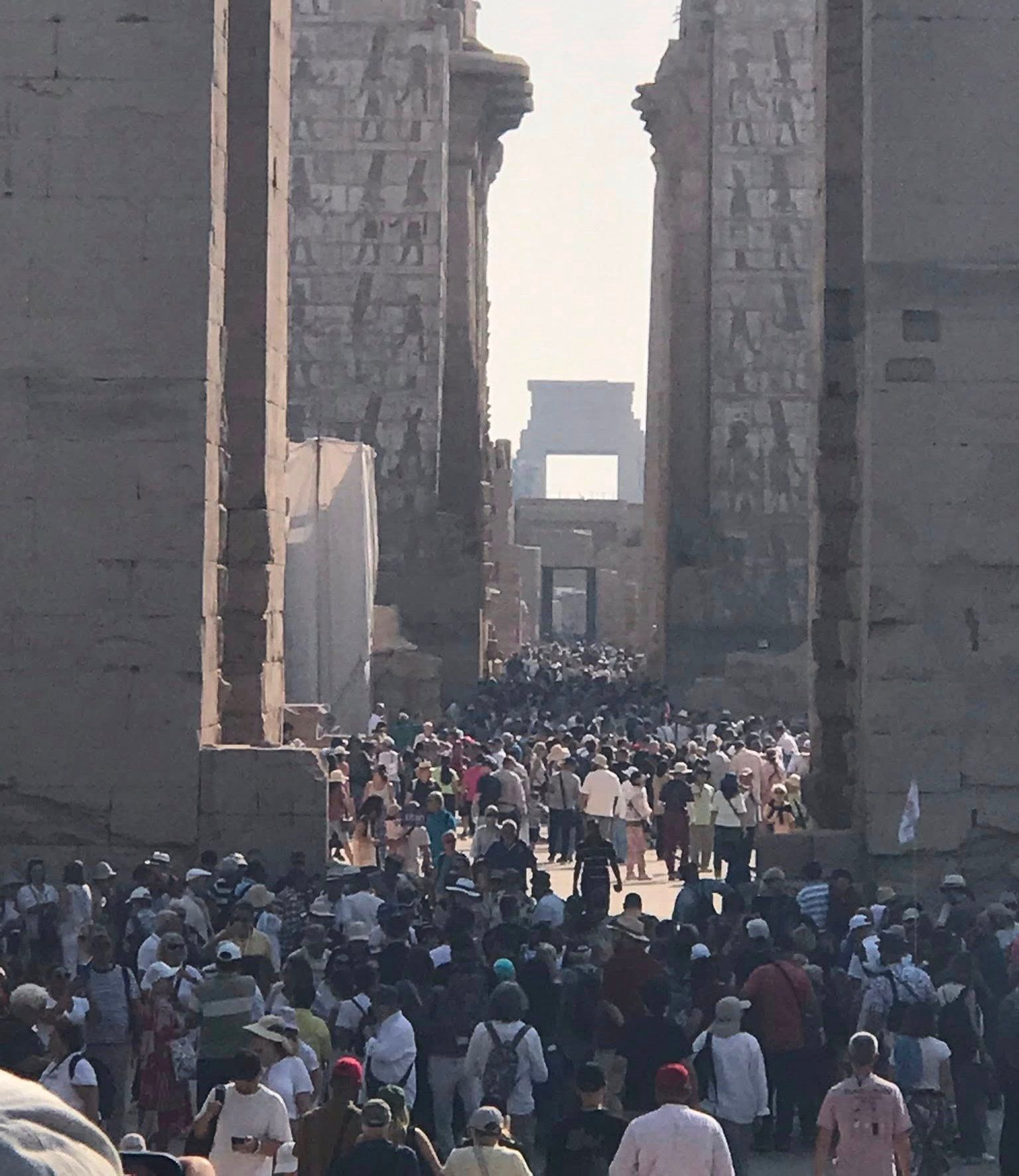 السياح الأجانب من حول العالم سعداء بين جدران وأعمدة معابد الأقصر