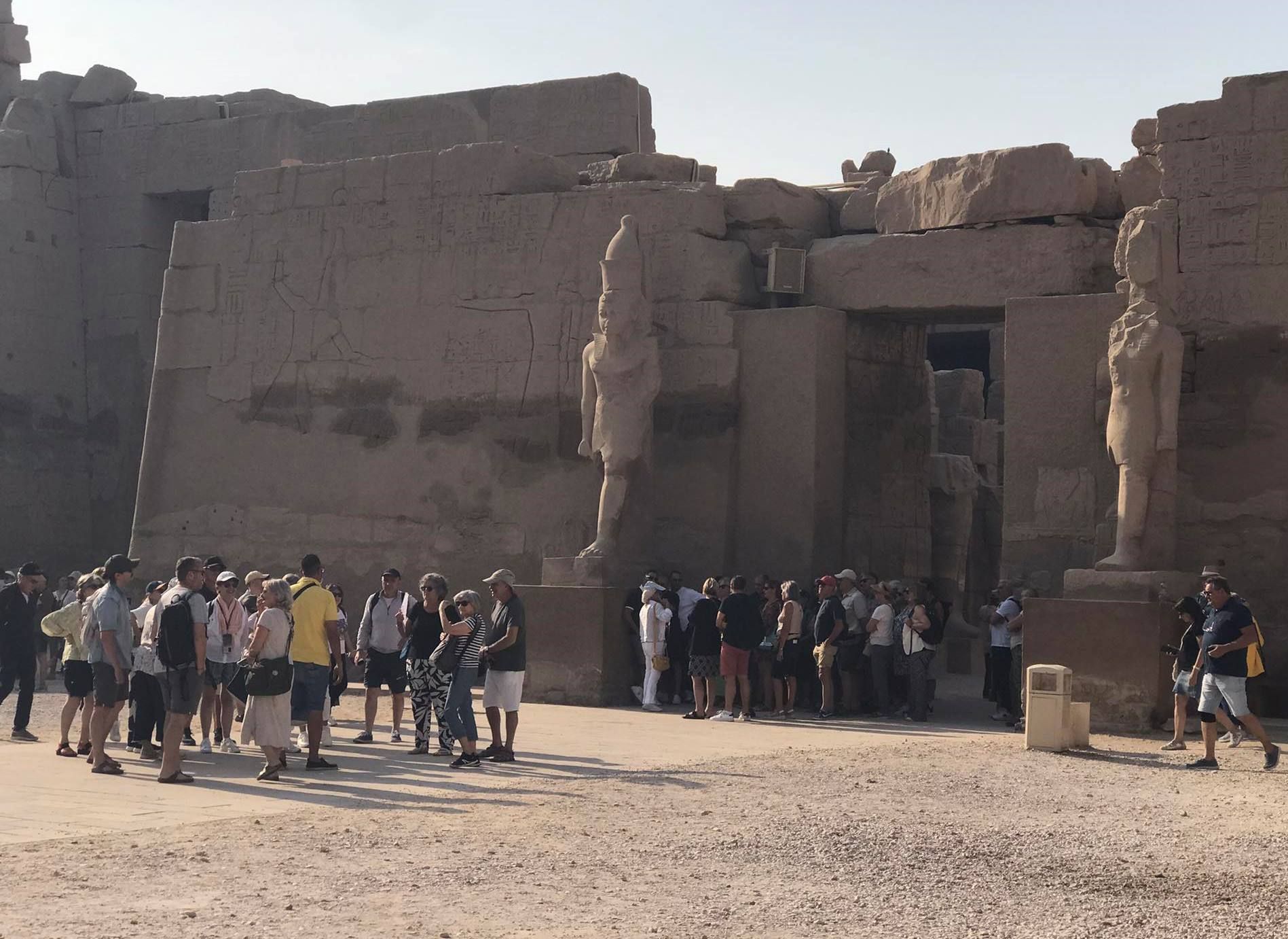 السياح من حول العالم سعداء بين جدران وأعمدة معابد الأقصر